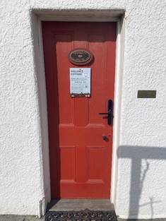 A red door with a sign on it

Description automatically generated with medium confidence