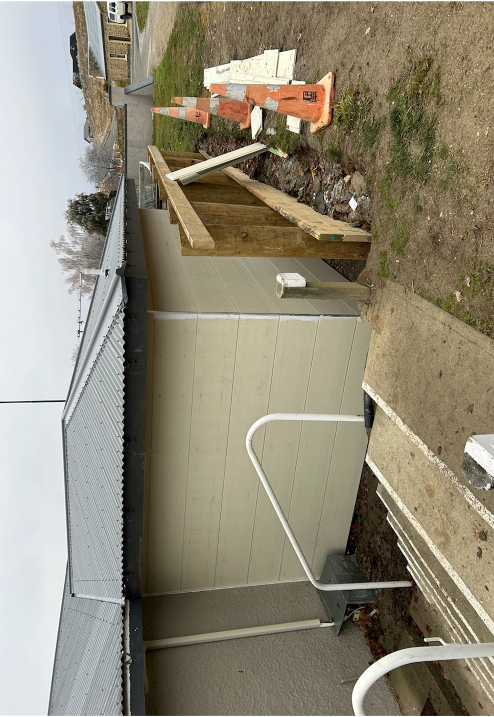 A building with a fence and construction equipment

Description automatically generated with medium confidence