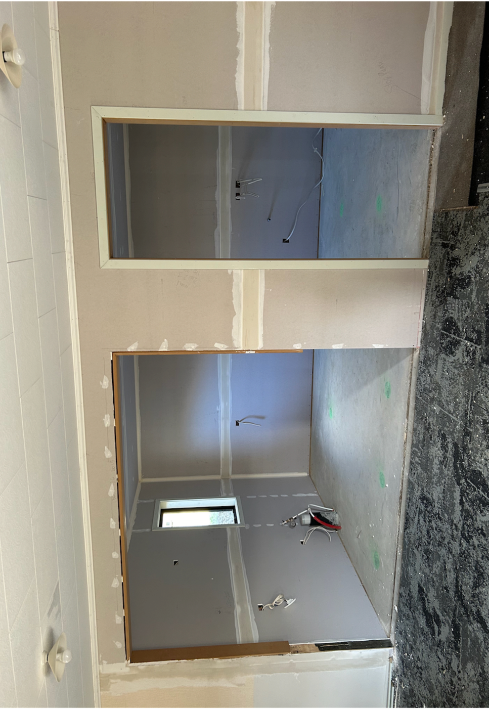 A room under construction with a door and a window

Description automatically generated