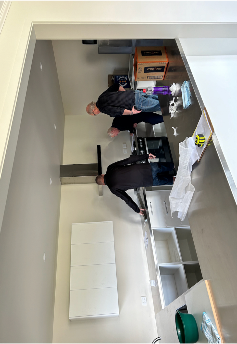 A couple of men in a kitchen

Description automatically generated