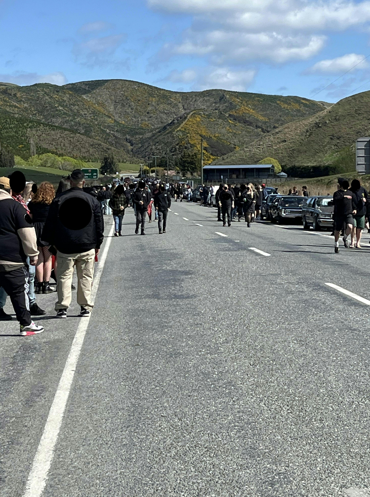 A group of people walking on a road

Description automatically generated