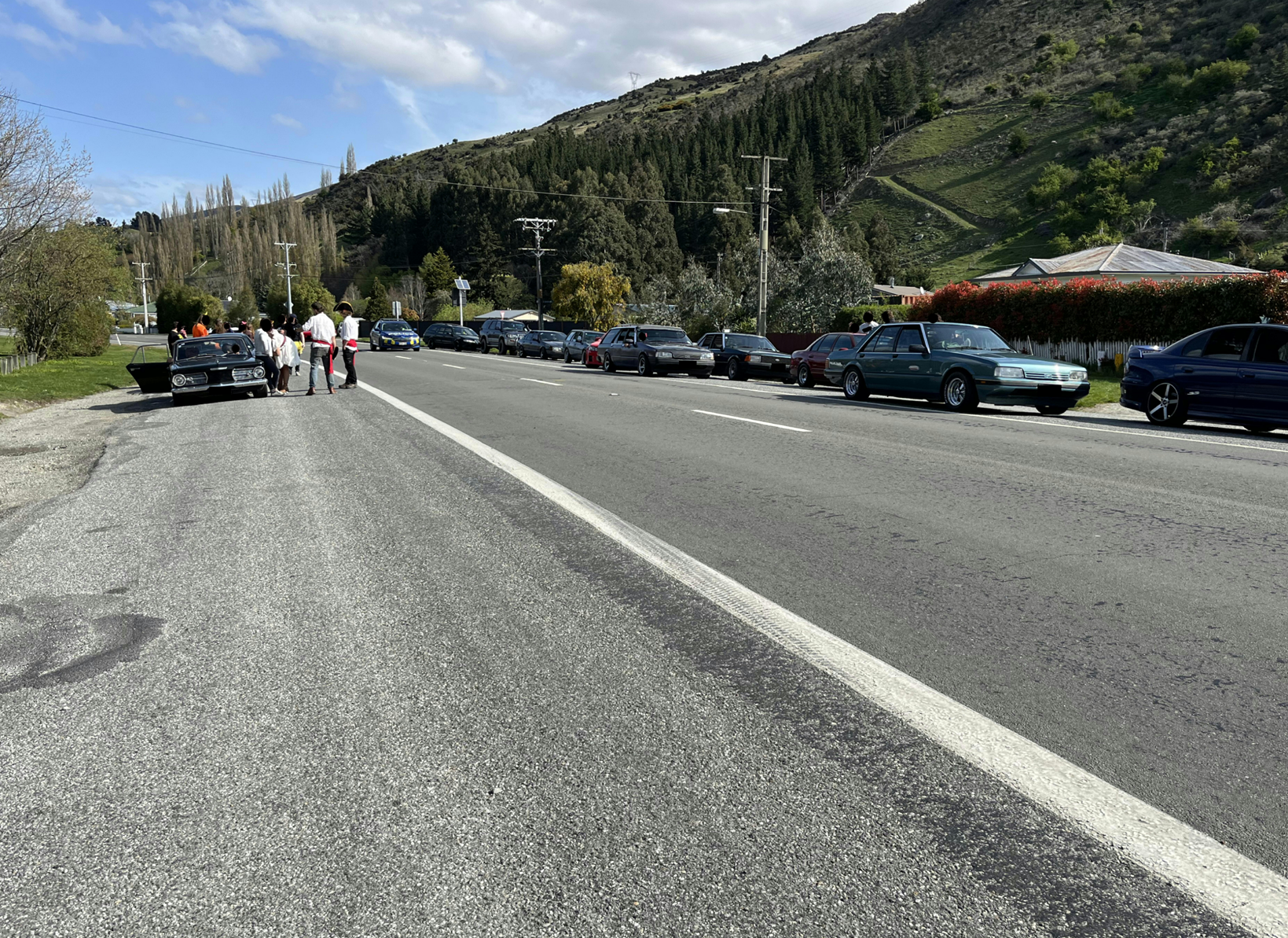 A road with cars parked on it

Description automatically generated