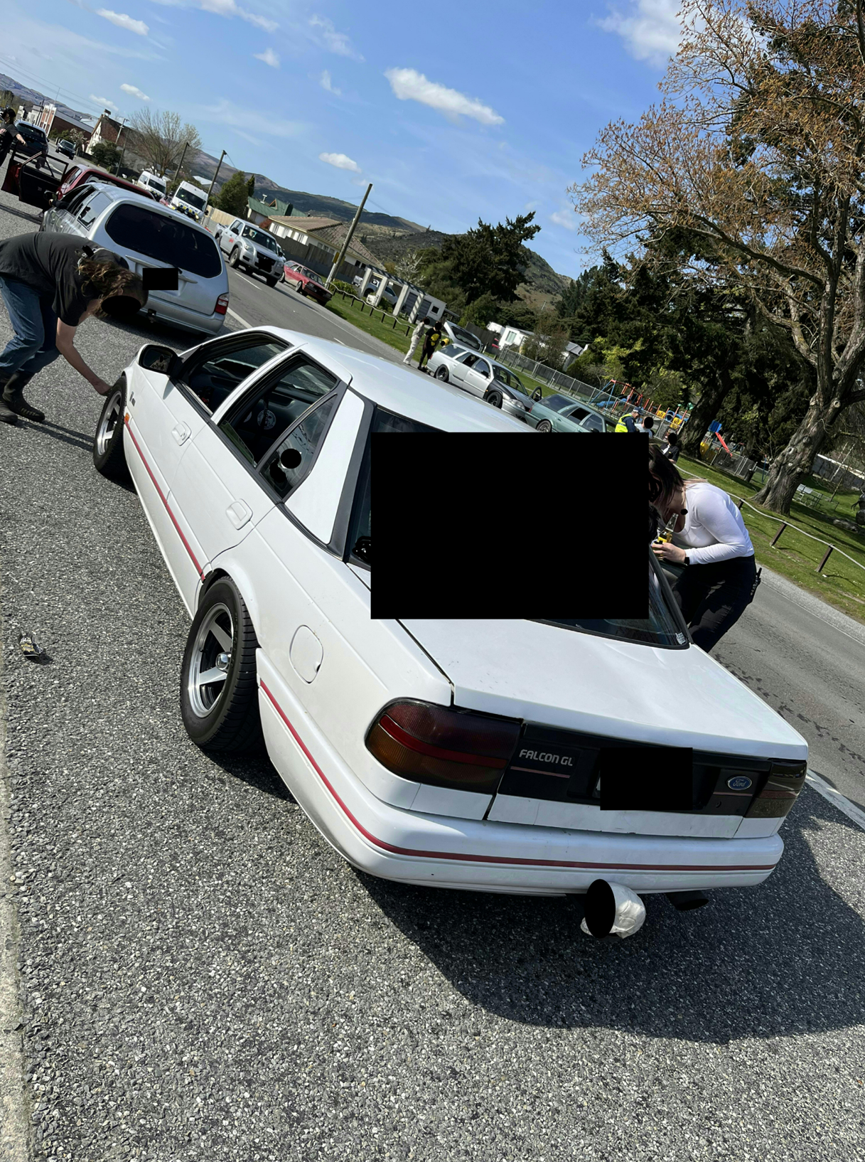 A white car with a black screen on the back

Description automatically generated