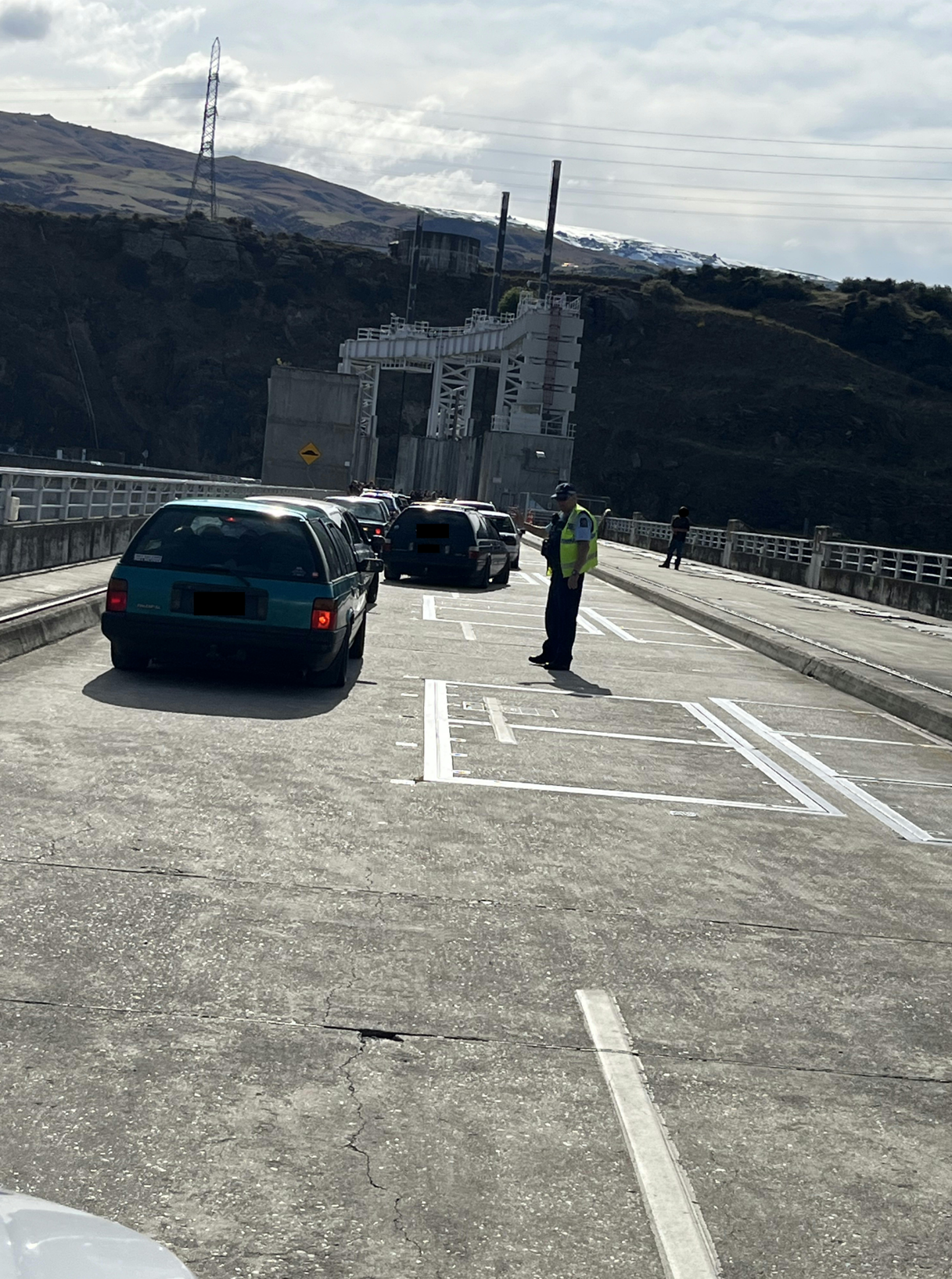 A police officer standing on a bridge

Description automatically generated