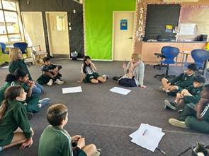 A group of students sitting in a circle

AI-generated content may be incorrect.